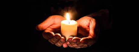 Image of hand holding candle by Myriam Zilles